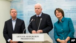 Le sénateur McCain (au milieu) en compagnie de ses collègues, le républicain Lindsey Graham et la démocrate Amy Klobucha, au palais présidentiel de Vilnius, en Lituanie