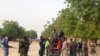Local volunteers carrying weapons stand in the Jiddari Polo area in Maiduguri, Nigeria, after an attack by Boko Haram militants, April 27, 2018.