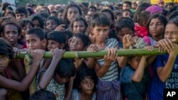 ក្មេងៗ​រ៉ូហ៊ីងយ៉ាង​កាន់​សាសនា​ឥស្លាម​ ដែល​បាន​រត់គេច​ពី​ប្រទេស​មីយ៉ាន់ម៉ា​ចូល​មក​ក្នុង​ប្រទេស​បង់ក្លាដែស​រង់ចាំ​ទទួល​យក​ជំនួយ​នៅ​ក្បែរ​ជំរំ​ភៀស​ខ្លួន Balukhali ប្រទេស​បង់ក្លាដែស កាលពី​ថ្ងៃទី២៥ ខែកញ្ញា ឆ្នាំ២០១៧។