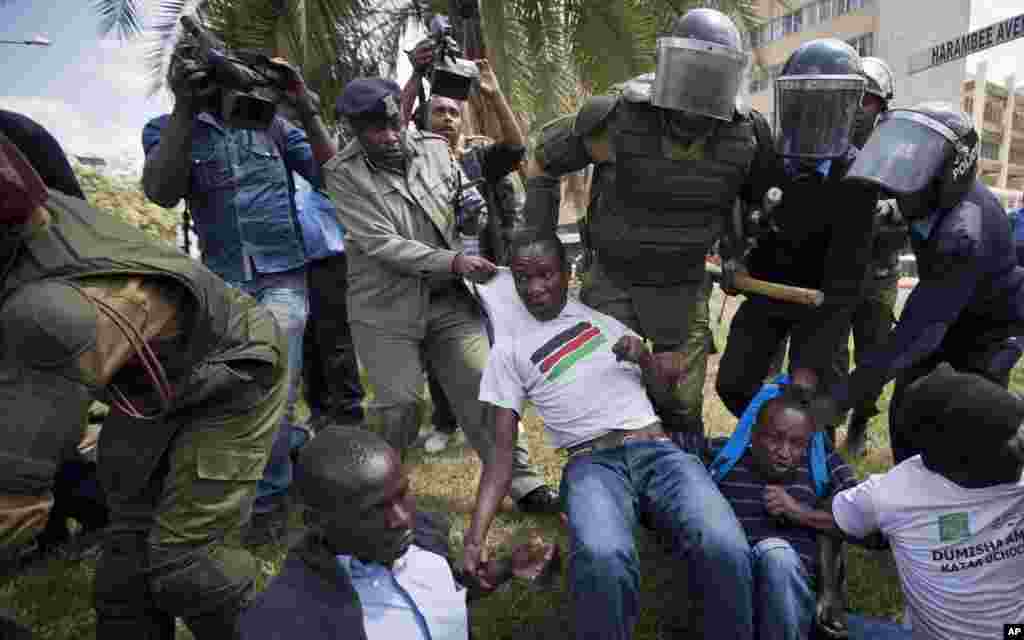 Des manifestants contre la nouvelle loi de sécurité sont arrêtés par la police anti-émeute après avoir crié contre la nouvelle loi, à l'extérieur du bâtiment du Parlement à Nairobi, au Kenya jeudi 18 décembre 2014.