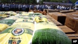 北京警察2011年5月在沒收的假冒偽劣糧食產品前宣傳防止經濟犯罪