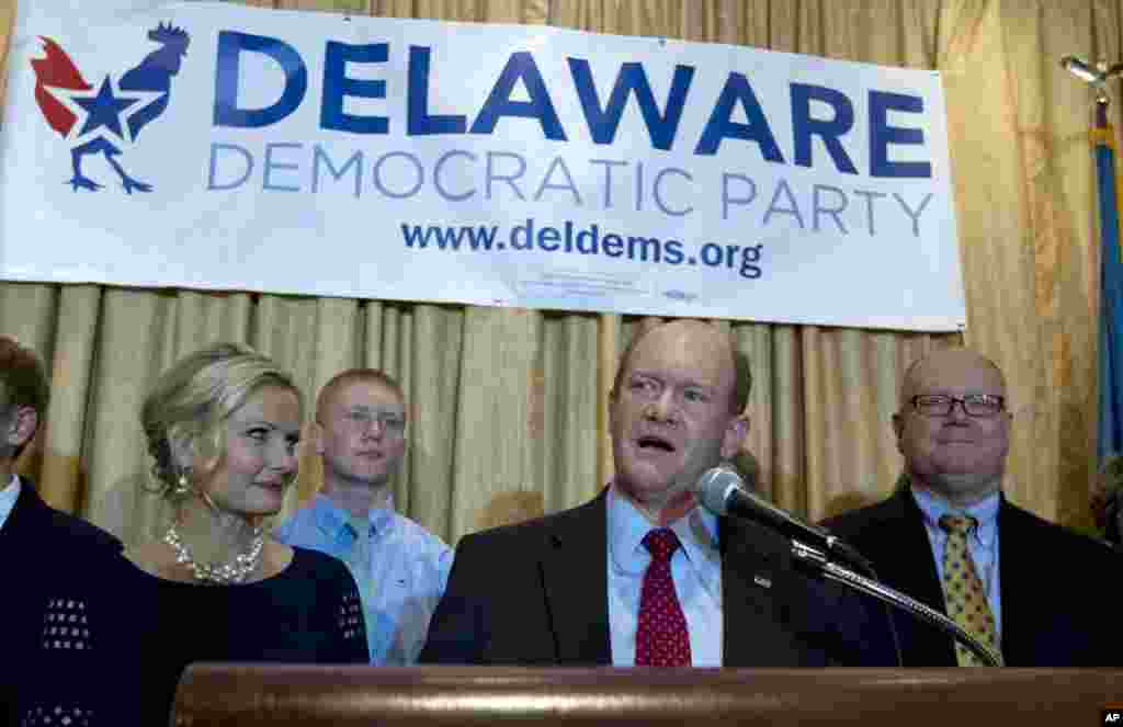 Le sénateur démocrate du Delaware, Chris Coons, accompagné de son épouse Annie, à gauche, et de sa famille, parle à ses partisans après avoir remporté sa réélection au Sénat, mardi 4 novembre 2014, lors de la soirée électorale de son parti à Newark, Delaware .