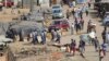 La police anti-émeute patrouille près d'un marché très fréquenté malgré le confinement à Harare au Zimbabwe, le 7 avril 2020.
