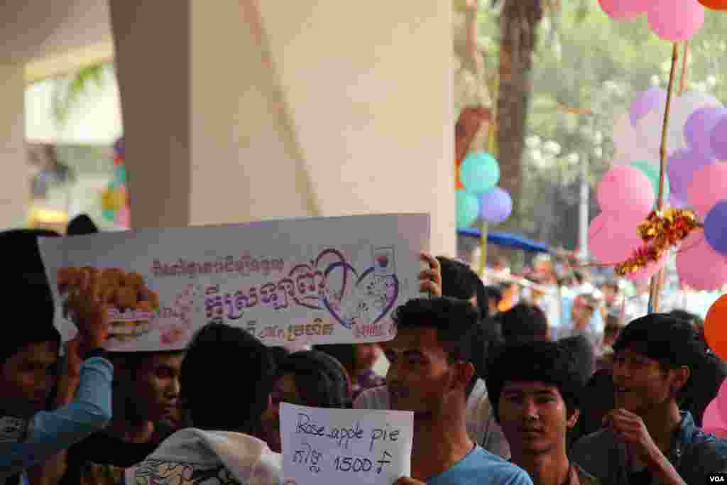 យុវជនម្នាក់លើកផ្លាកបង្ហាញពីតម្លៃម្ហូបដែលខ្លួនលក់នៅក្នុងកម្មវិធីសប្បុរសធម៌លើកទី៦របស់សាកលវិទ្យាល័យភូមិន្ទភ្នំពេញ កាលពីថ្ងៃទី១៤ ខែកុម្ភៈ ឆ្នាំ២០១៥។ ខណៈពេលដែលយុវជនជាច្រើនបានយកថ្ងៃទី១៤ ខែកុម្ភៈ មកបង្ហាញពីក្តីស្រឡាញ់ ដោយឡែកនៅឆ្នាំ២០១៥នេះមានស្ថាប័នជាច្រើនបានយកថ្ងៃ១៤កុម្ភៈនេះ មកបង្កើតជាកម្មវិធីផ្សេងៗ ដើម្បីជាប្រយោជន៍ដល់សង្គមជំនួសវិញ ដូចជាកម្មវិធីសប្បុរសធម៌នៅសាកលវិទ្យាល័យភូមិន្ទភ្នំពេញជាដើម។ (នូវ ពៅលក្ខិណា/VOA)