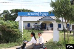 សិស្សសាលា​ជិះ​ម៉ូតូ​កាត់​សាលាឃុំ​ព្រៃ​ខ្លា នៅ​ក្នុង​ស្រុកកោះអណ្តែត ខេត្តតាកែវ (ស៊ុន ណារិន/VOA)