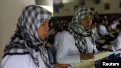 A migrant worker heading for Middle East countries holds her passport documents at an immigration office in Tangerang, Indonesia's Banten province, file photo.