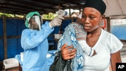 Une femme subit un test de température dans le cadre de la prévention Ebola , avant d'entrer dans l'hôpital public Macauley à Freetown , Sierra Leone , le 21 janvier 2016. (AP Photo/Aurelie Marrier d'Unienville)\\ 