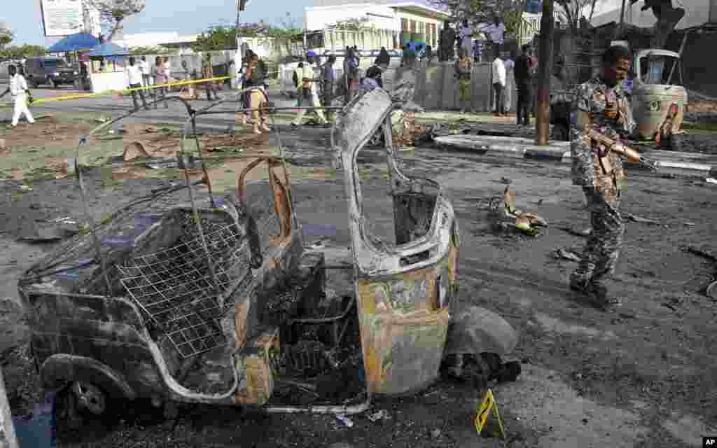 Un soldat somalien passe devant une moto après l'explosion d'une voiture piégée près du Parlement, à Mogadiscio, en Somalie, le 25 mars 2018.
