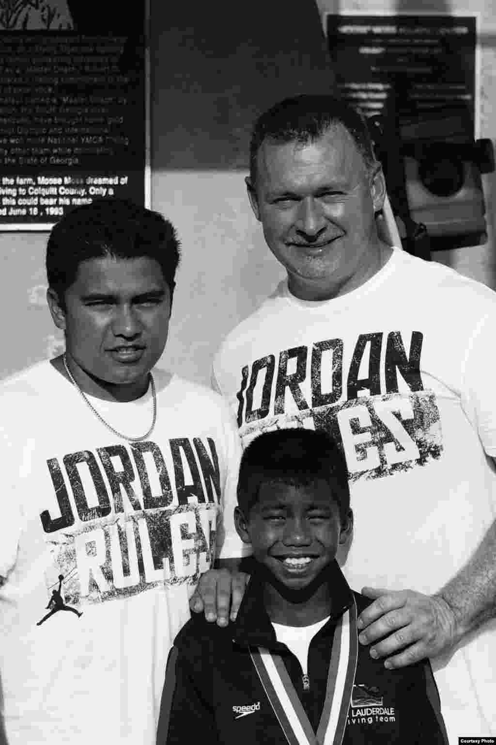 Jordan Pisey Windle ដែលជាកីឡាករលោតទឹកថ្នាក់ជាតិវ័យក្មេងដ៏ឆ្នើមម្នាក់របស់សហរដ្ឋអាមេរិក ថតរូបជាមួយឪពុកទាំងពីរនាក់របស់គេ គឺលោក Jerry Windle និងលោក Andres Rodriguez ក្រោយពីការប្រកួត។ (រូបថតផ្តល់ឲ្យ)