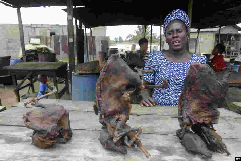 Vivian Koshefobamu, vendeuse de viande du gibier, 45 ans, parle devant la viande de brousse sèche, au marché Ajegunle-Ikorodu à Lagos, au Nigeria, le 13 août 2014. Les animaux infectés tels que les chimpanzés, les gorilles, les chauves-souris frugivores, les singes, les antilopes et les porcs épics trouvés malades ou morts dans la forêt tropicale peuvent être des porteurs naturels du virus Ebola. AFP PHOTO / PIUS UTOMI EKPEI