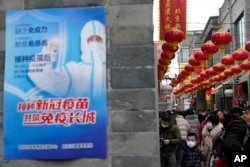 北京街頭一幅接種新冠疫苗的宣傳畫。（2021年2月14日）