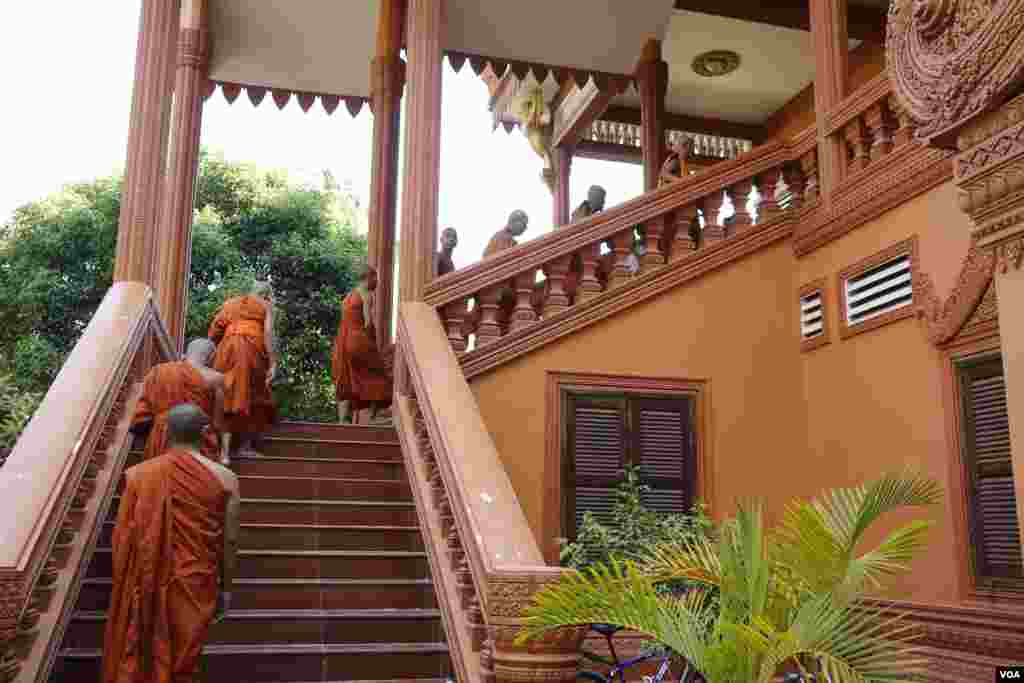 ព្រះសង្ឃនិមន្តឡើងកាំជណ្តើរព្រះវិហារ នៅវត្តរាជបូព៌ នៅខេត្តសៀមរាប កាលពីថ្ងៃទី២៥ ខែមេសា ឆ្នាំ២០១៧។ (ស៊ុន ណារិន/VOA)