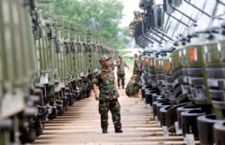 FILE PHOTO - A Cambodian army soldier looks at Chinese military vehicles displayed before a handover ceremony at a military airbase in Phnom Penh, Cambodia, Wednesday, June 23, 2010.