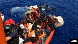 L'ONG française SOS Mediterranée secourant 51 migrants, qui dérivaient sur un bateau en bois, au large des côtes de l'île de Lampedusa, le 25 juin 2020.
