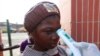 Wani Malami na amfani da na’urar auna zafin jiki domin neman alamun cutar Ebola. 