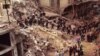 FILE - Firefighters and rescue workers search through the rubble of the Buenos Aires Jewish Community center after a car bomb rocked the building, July 18, 1994. 