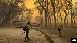 En esta foto suministrada por el departamento de bomberos de Flower Mound, Texas, se ve a bomberos que se dirigen a combatir un incendio en el extremo norte de Texas el martes 27 de febrero de 2024. 