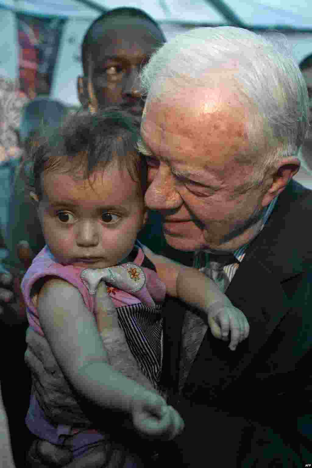 Jimmy Carter porte un enfant palestinien à Jérusalem-Est, lors d'une rencontrer avec des Palestiniens, le 21 octobre 2010. (Menahem KAHANA /AFP)