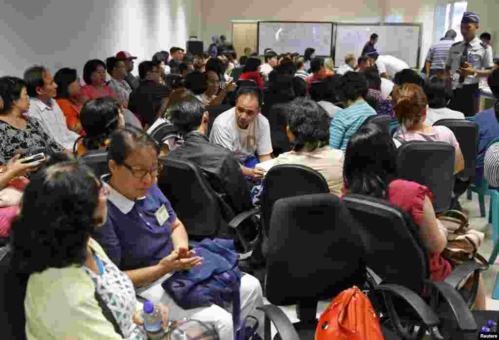 Family of passengers onboard AirAsia flight QZ8501 sit at a waiting area in Juanda International Airport, Surabaya, Dec. 28, 2014.