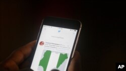 Un homme utilise son téléphone portable pour lire les gros titres de Twitter dans un bureau à Lagos, au Nigeria, le 7 juin 2021.