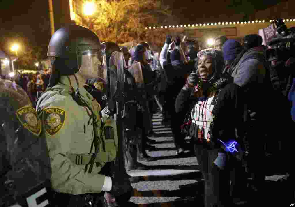 Les policiers montent la garde alors que les manifestants réagissent à l'annonce de la décision du grand jury de ne pas inculper agent de police Darren Wilson dans la fusillade mortelle de Michael Brown, à Ferguson, Missouri, le 24 novembre 2014.