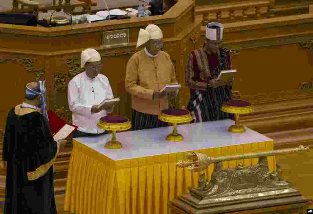 Htin Kyaw, second right, takes oaths as Myanmar's new president during a sworn-in ceremony in Myanmar's parliament in Naypyitaw.