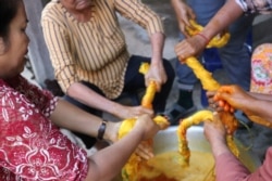 អ្នកស្រី មុំ ឡាយ ធ្វើការនៅនៅអង្គការ វិទ្យាស្ថានវាយនភណ្ឌប្រពៃណីខ្មែរ Institute of Khmer Traditional Textiles កំពុងតែជ្រលក់សូត្រជាមួយនឹងលក្ខធម្មជាតិឲ្យចេញពណ៌លឿងជាមួយនឹងអ្នករួមការងាររបស់អ្នកស្រី នៅក្នុងស្រុកអង្គរធំខេត្តសៀមរាប កាលពី ថ្ងៃទី២១ ខែកក្កដា ឆ្នាំ២០២០។