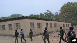 Photo d’archives : Les forces de sécurité devant une école secondaire publique incendiée dans la ville de Chibok, Nigeria – 21 avril, 2014.