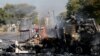 Un habitant passe devant un camion incendié près de la route où les manifestants sont passés à Atteridgeville, à l'ouest de Pretoria, Afrique du Sud, le 21 juin 2016.