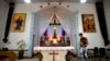 FILE - A parishioner walks past the altar as members of Lower Dafei Catholic Church hold an impromptu prayer vigil as they wait for Chinese officials to arrive and cut down their church's cross in Lower Dafei Village near Wenzhou in eastern China's Zhejia