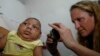 Pediatrician Alexia Harrist from the United States' Centers for Disease Control and Prevention (CDC) takes a picture of 3-month-old Shayde Henrique who was born with microcephaly, after examining him in Joao Pessoa, Brazil, Feb. 23, 2016. 