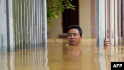 បុរសម្នាក់ដើរកាត់ទឹកជំនន់នៅក្រៅផ្ទះរបស់ខ្លួនក្នុងខេត្ត Thai Nguyen កាលពីថ្ងៃទី១០ កញ្ញា ឆ្នាំ២០២៤។