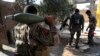 FILE - U.S.-backed Syrian Democratic Forces fighters, prepare to fire a mortar shell, at one of the front lines, in Raqqa city, northeast Syria, July 27, 2017.