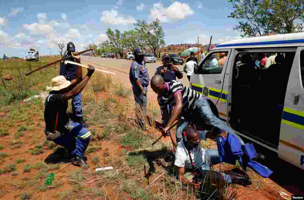 Miners encounter police at the AngloGold Ashanti mine in Carletonville, South Africa, October 18, 2012.