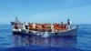 Migrants sit in their boat during a rescue operation by the Italian navy off the coast of Sicily in this handout picture from the Italian Marina Militare, released May 6, 2016. Italy's coast guard rescued about 1,000 people off the country's southern tip Thursday.