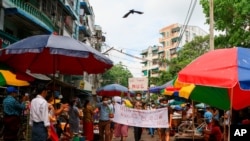 រូបឯកសារ៖ បាតុករ​ប្រឆាំង​ការ​ធ្វើ​រដ្ឋប្រហារ​កាន់​បដា​ដែលសរសេរ​ថា «យើងគាំទ្រ​រដ្ឋាភិបាល​រួបរួម​ជាតិ»​ ពេល​ពួកគេ​ធ្វើបាតុកម្ម​តាម​ដងផ្លូវ​កាលពី​ថ្ងៃទី១៧ ខែមេសា ឆ្នាំ២០២១ នៅ​ទីក្រុង​ Yangon ប្រទេស​មីយ៉ាន់ម៉ា។ (AP)