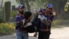 Rescue workers assist an injured student from the shooting at Directorate of Agriculture Institute in Peshawar, Pakistan, Dec. 1, 2017. 