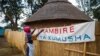 Hatifari Munongi, poète, conteuse et institutrice à la retraite, ajuste une banderole de bienvenue dans la réplique d’une habitation traditionnelle qu'elle a installé dans l'arrière-cour de sa maison dans la banlieue de Marlborough à Harare le 18 octobre 2018