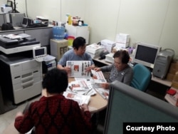 North Korean defectors, working for FreeNK newspaper in South Korea, wrap editions of paper in plastic, ready for the air drop. (Photo: Jason Godman / VOA)