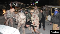 Soldiers carry a victim of a blast targeting a police truck in Quetta, Pakistan, Jan. 9, 2018. 