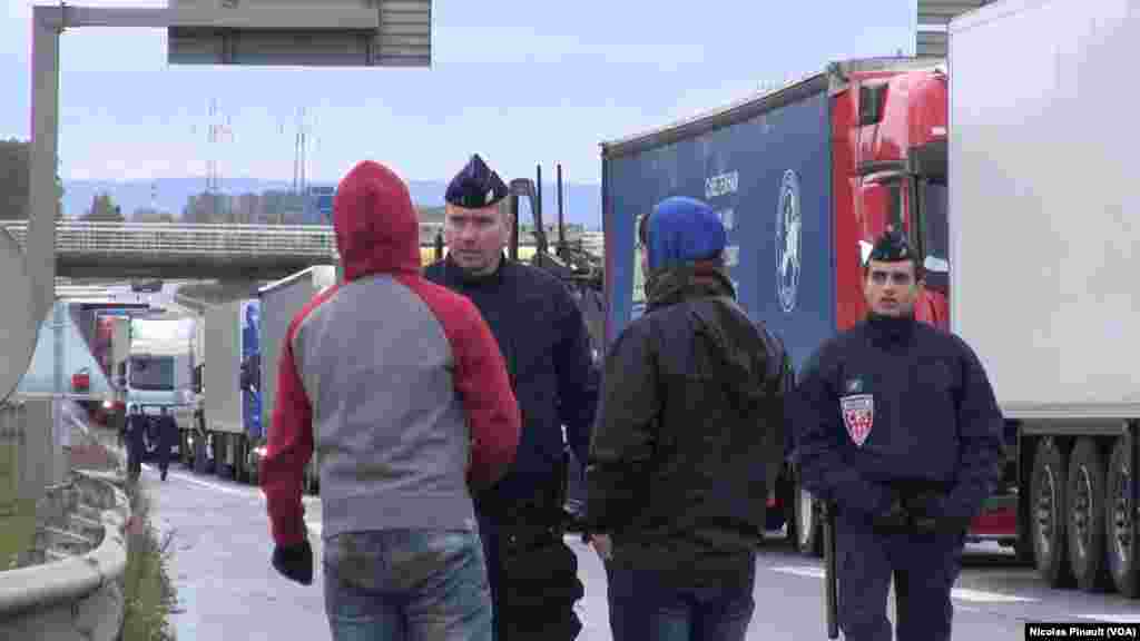 Deux policiers font face à deux migrants près de Calais, 14 octobre 2015 (Nicolas Pinault/VOA). 