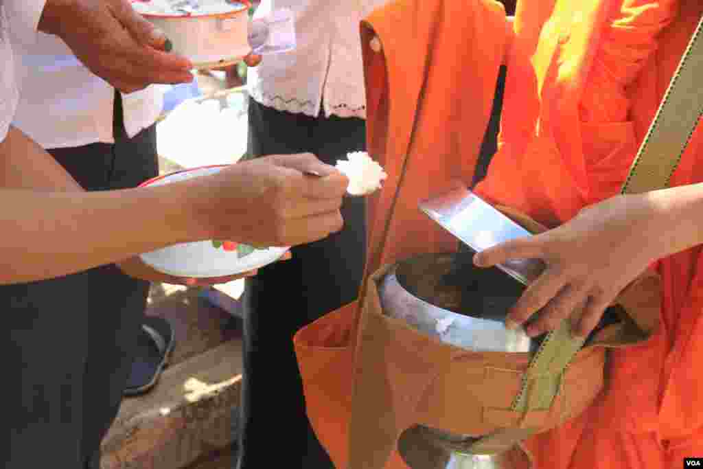 ពុទ្ធបរិស័ទ ដាក់បាត្រ នៅក្នុងការប្រារព្ធពីធីបុណ្យពិសាខបូជា នៅភ្នំឧត្តុង្គ ក្នុងខេត្តកណ្តាល នៅថ្ងៃទី១០ ខែឧសភា ឆ្នាំ២០១៧។ (ហ៊ាន សុជាតា/VOA)
