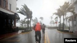 Des habitants marchent près de la plage à Miami Beach, le 10 septembre 2017.