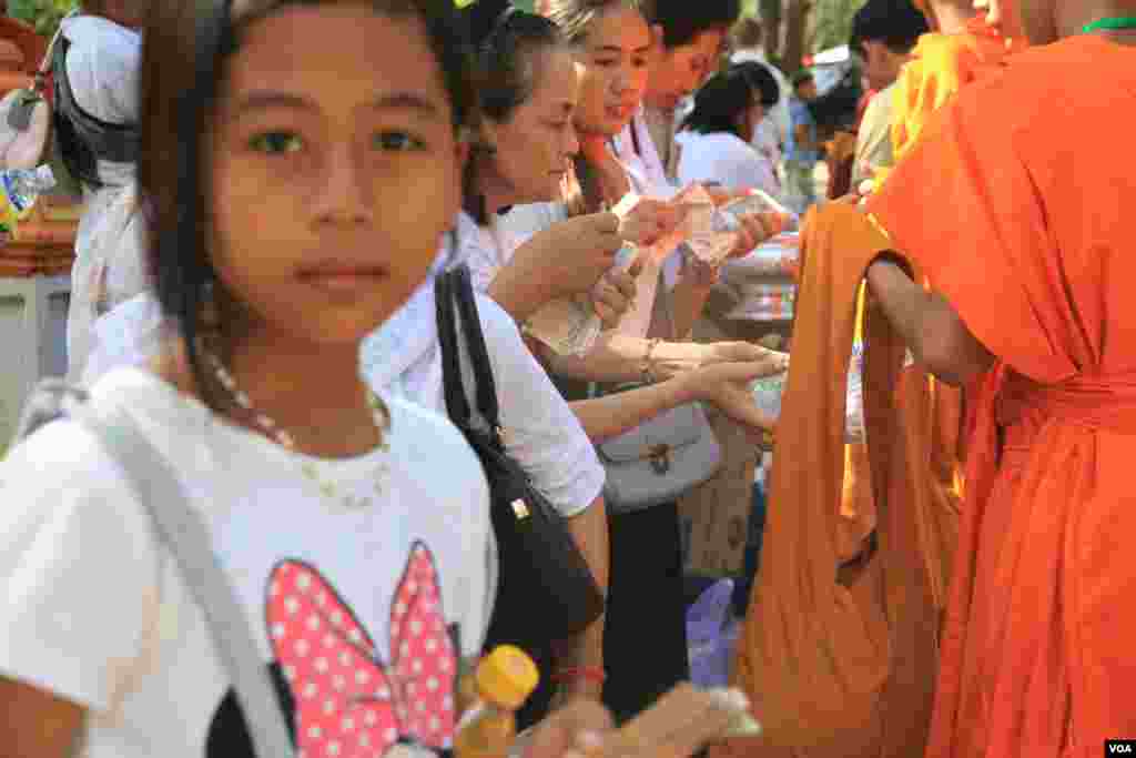 ពុទ្ធបរិស័ទ ដាក់បាត្រ នៅក្នុងការប្រារព្ធពីធីបុណ្យពិសាខបូជា នៅភ្នំឧត្តុង្គ ក្នុងខេត្តកណ្តាល នៅថ្ងៃទី១០ ខែឧសភា ឆ្នាំ២០១៧។ (ហ៊ាន សុជាតា/VOA)