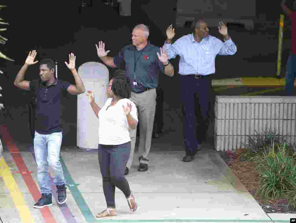 Les passagers, mains levées, abandonnent leurs bagages à l’extérieur de l'aéroport international de Fort Lauderdale, en Floride, 6 janvier 2017.