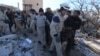 People and Civil Defense members carry a dead body removed from a destroyed Medecins Sans Frontieres (MSF) supported hospital hit by missiles in Marat Numan, Idlib province, Syria, Feb. 16, 2016. 