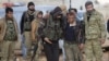 FILE - Free Syrian Army fighters help a fellow fighter, who was injured during fighting near Qabasin town, northern Syria, Jan. 12, 2017.