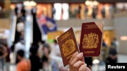 英国国民海外护照2021年1月31日开始，成为香港人出离压迫的单程车票。图为一名香港示威者在反对港版国安法的抗议中手举英国国民海外护照。（路透社2020年6月1日资料照）
