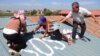 People in Tropeang Lavear display SOS messages on their roofs, which lies in the flight path to Phnom Penh international airport, Cambodia, November 13, 2014. (Nov Povleakhena/VOA Khmer)
