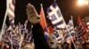 FILE - A supporter of Greece's extreme right Golden Dawn party raises his hand in a Nazi-style salute during a rally in Athens.